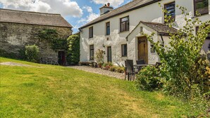 A traditional stone building with a white facade and a tiled roof.