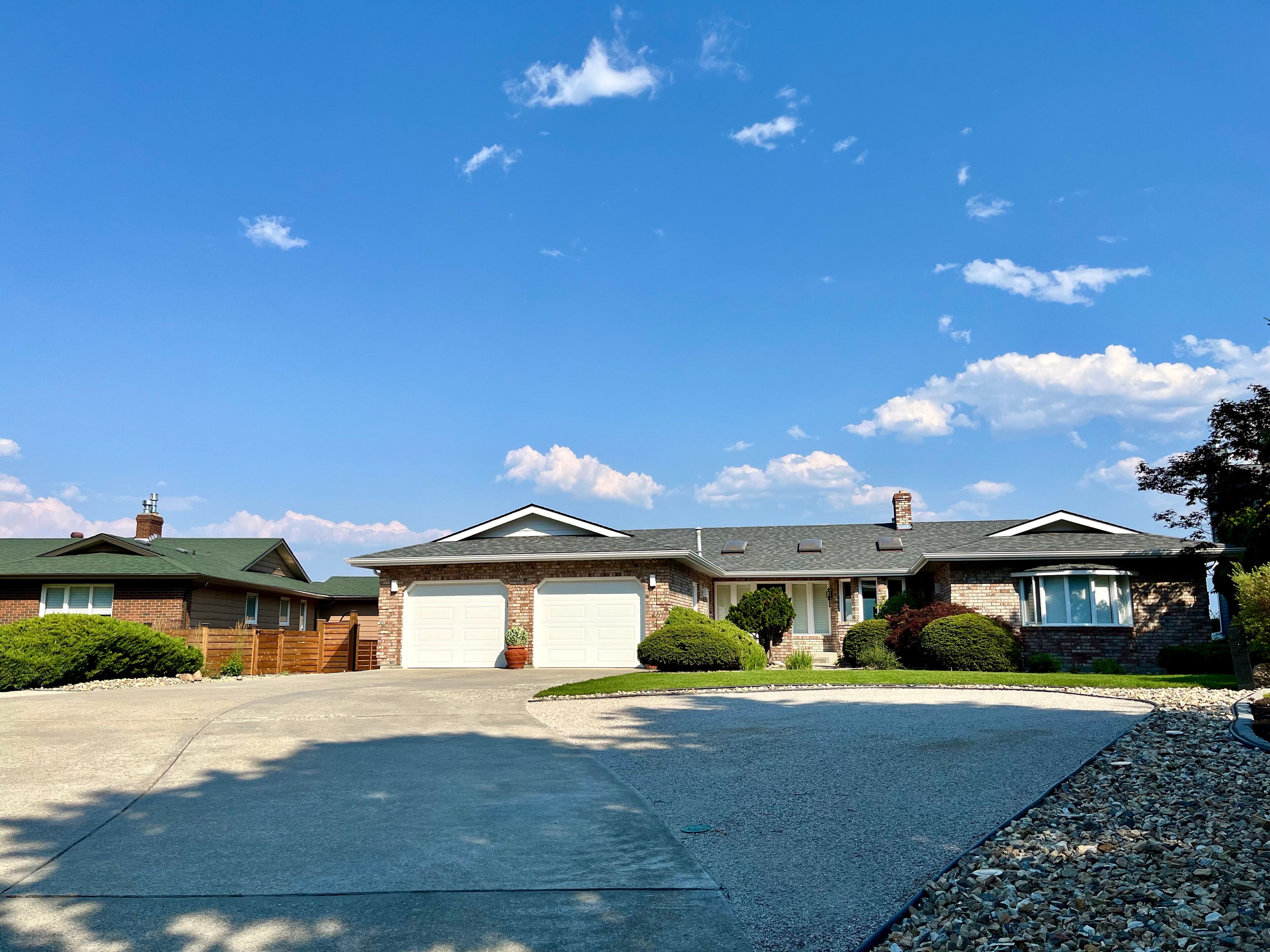 A two-story house with a garage, a driveway, and a well-maintained lawn.