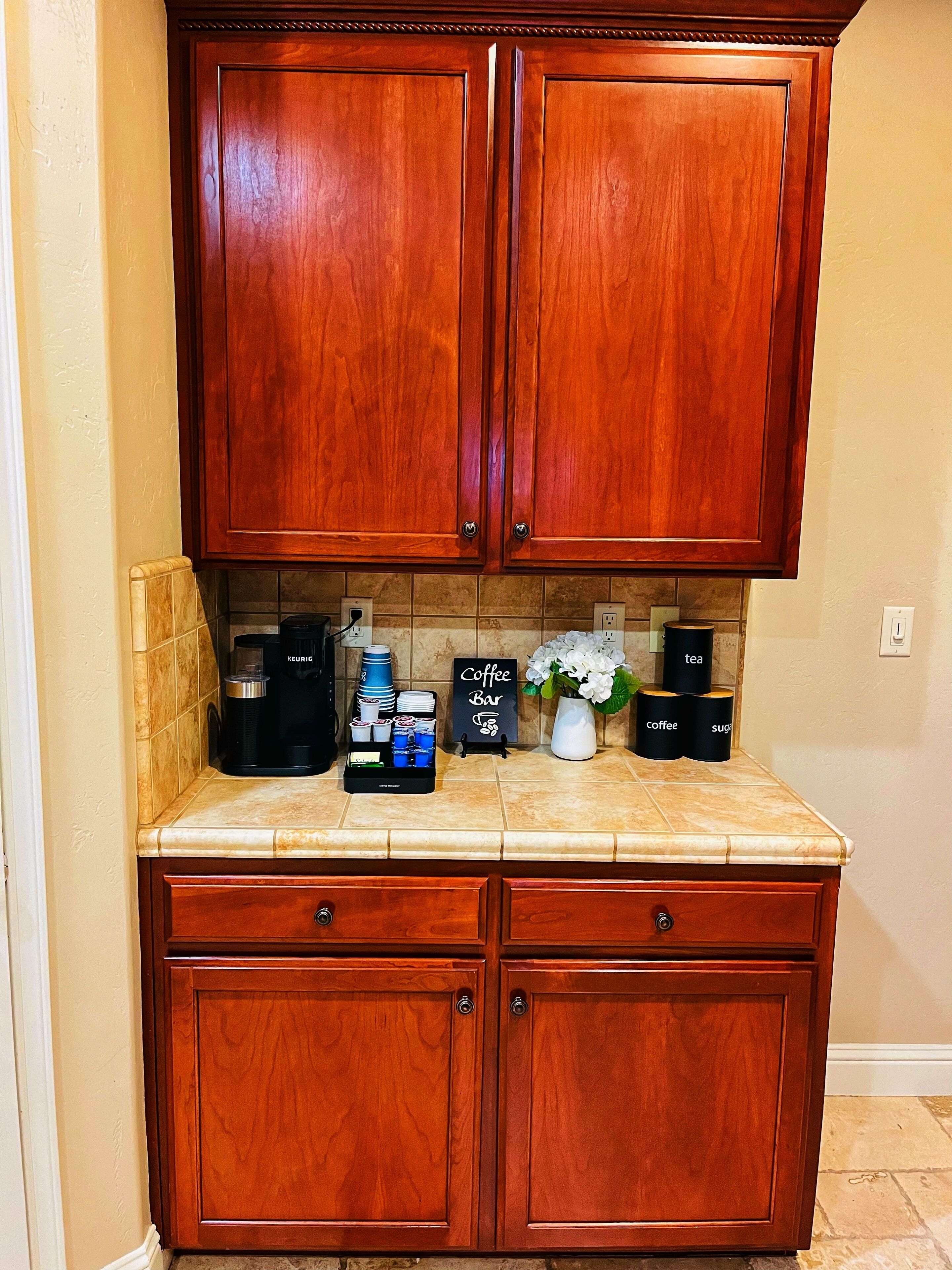 A kitchen with wooden cabinets, a coffee station, and a sign that reads "Coffee Bar".
