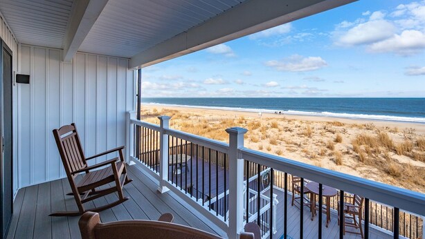 A wooden deck with a railing overlooking a beach. - Oceanfront Private Home With Amazing Views (Ocean City)