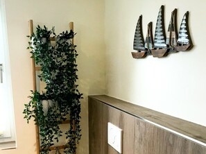 En træbænk med en metalkunstinstallation af sejlbåde på væggen.