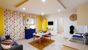 A compact living space with a dining area, kitchenette, and a sofa. - Vacation home in the center 5 minutes from the National Museum, Duomo, Sanita (Napoli)