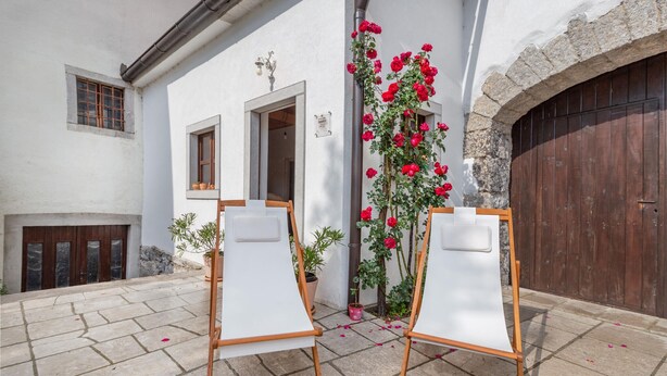 Two easels with blank canvases in front of a building with a stone archway and a wooden door. - Lovely apartment in Divaca with WiFi (Divaca)