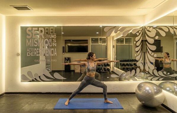 Ein Yoga-Studio mit Spiegelwand, Übungsbällen und einer blauen Yogamatte.