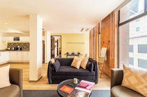 A modern living room with a sofa, coffee table, and a dining area in the background. - Kukun Grand Chapultepec (Mexico City)
