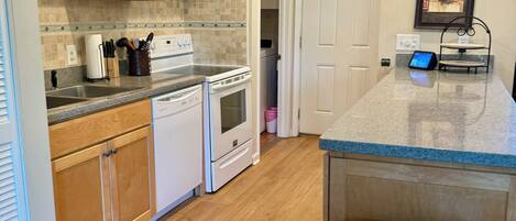A modern kitchen with wooden cabinets, a stainless steel refrigerator, and a built-in oven.