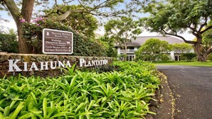 A sign for Kiahuna Plantation with directions to various facilities.