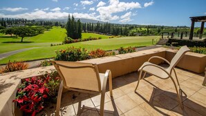 Une terrasse avec deux chaises et une vue sur un terrain de golf.