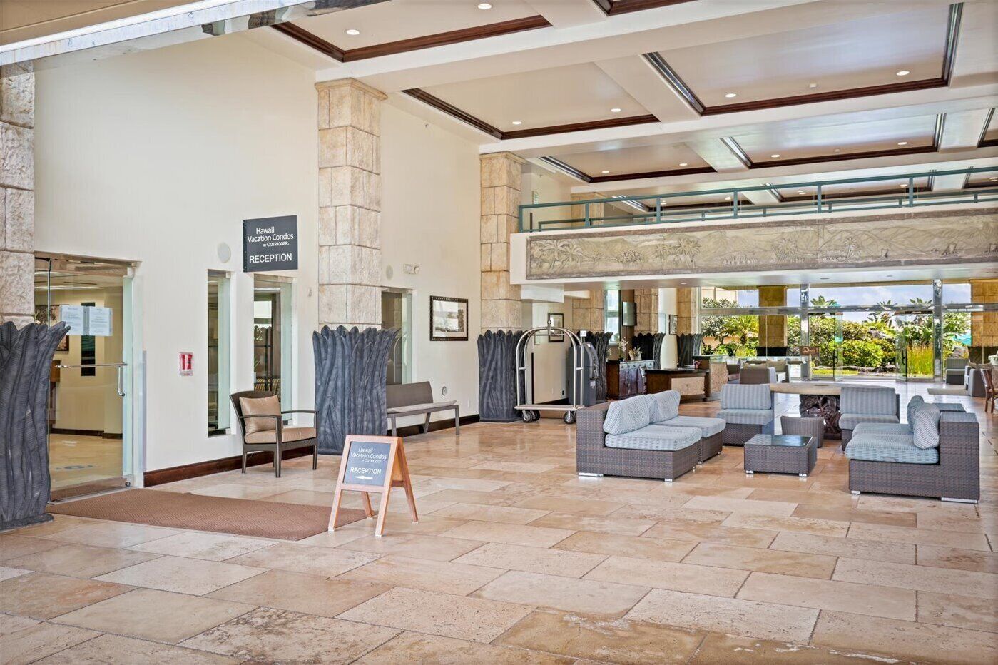 A spacious lobby with a reception desk, seating area, and a view of the outdoors.