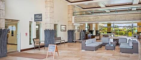 A spacious lobby with a reception desk, seating area, and a view of the outdoors.