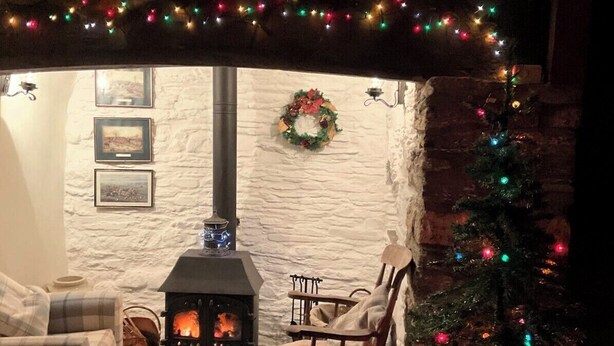 Una sala de estar acogedora con chimenea, un árbol de Navidad y decoraciones festivas.