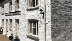 Un edificio de piedra blanca con varias ventanas y una chimenea.