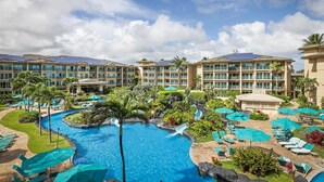A resort with multiple buildings, a central swimming pool, and surrounding lounge areas.