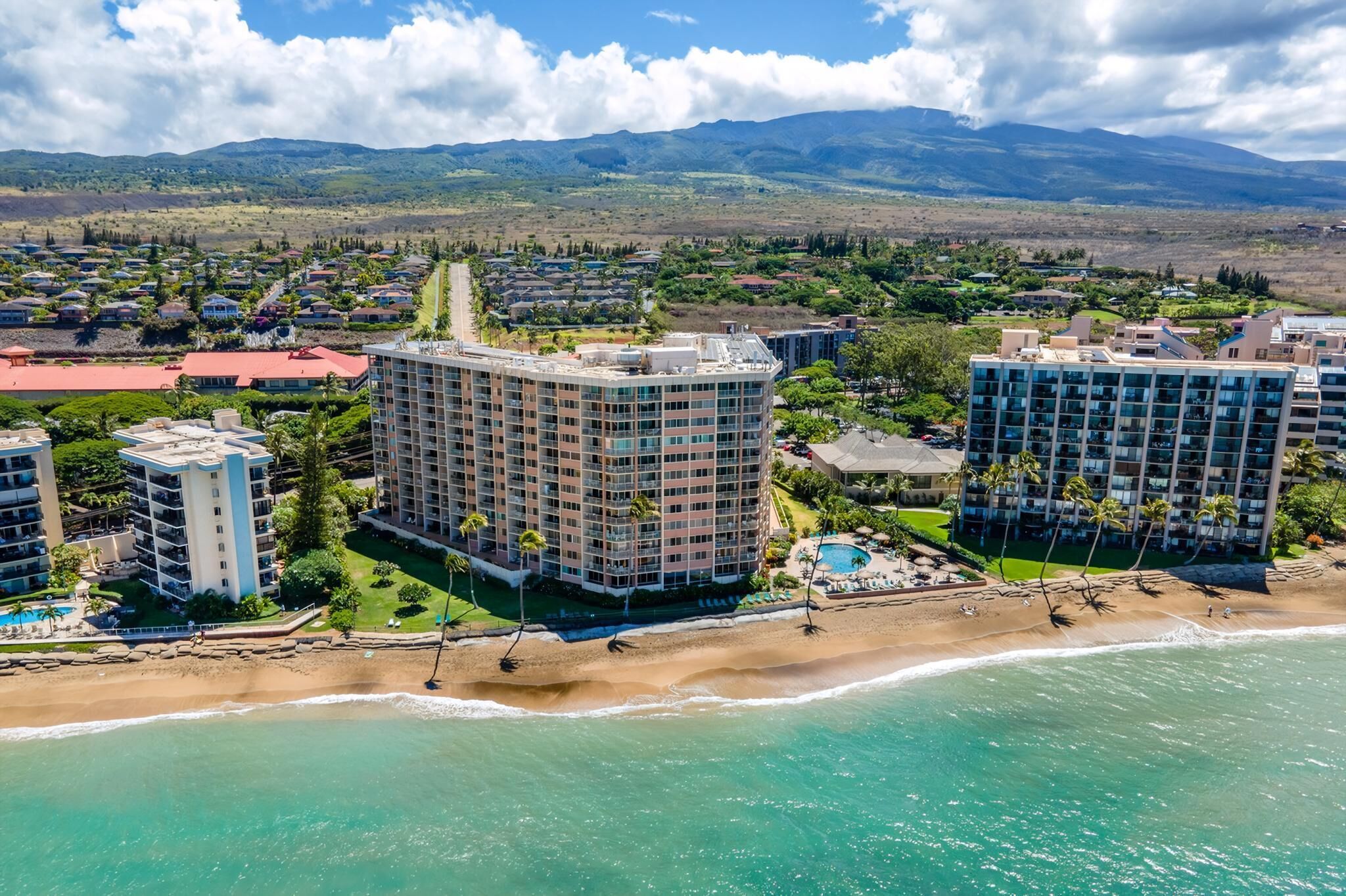 Une station balnéaire dotée de nombreux immeubles de grande hauteur, d’une plage et bordée de montagnes.