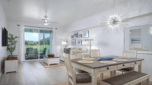 Un comedor con una mesa, sillas y un ventilador de techo.