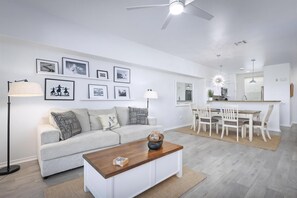A modern living room with a sofa, coffee table, and dining area. - Fairways Villas at Waikoloa B4 Golf View 2 Bedroom (Waikoloa)