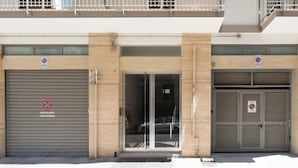 A building with two closed garage doors, each with a 'No Parking' sign. - Appartamento Onda Blu by Wonderful Italy (Bari)