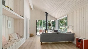 A spacious room with a large window, a fireplace, and a sofa. - 3 bedroom amazing home in Nykøbing Sj (Nykøbing Sj)