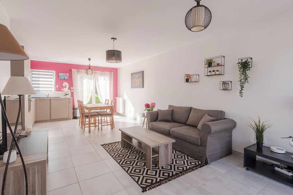 A modern living room with a sofa, coffee table, and dining area.