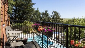 Un balcon avec une piscine, un espace salon extérieur et des jardinières.