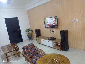 Relax in this stylish living room with a flat-screen TV, entertainment unit, and cozy seating area.
