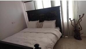 Restful retreat with a large bed, white duvet, and decorative pillows.