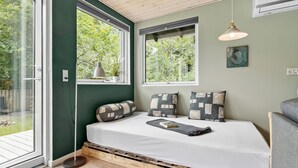A cozy bedroom with a bed, two windows, a pendant light, and a view of greenery outside. - 2 bedroom nice home in Rønde (Rønde)