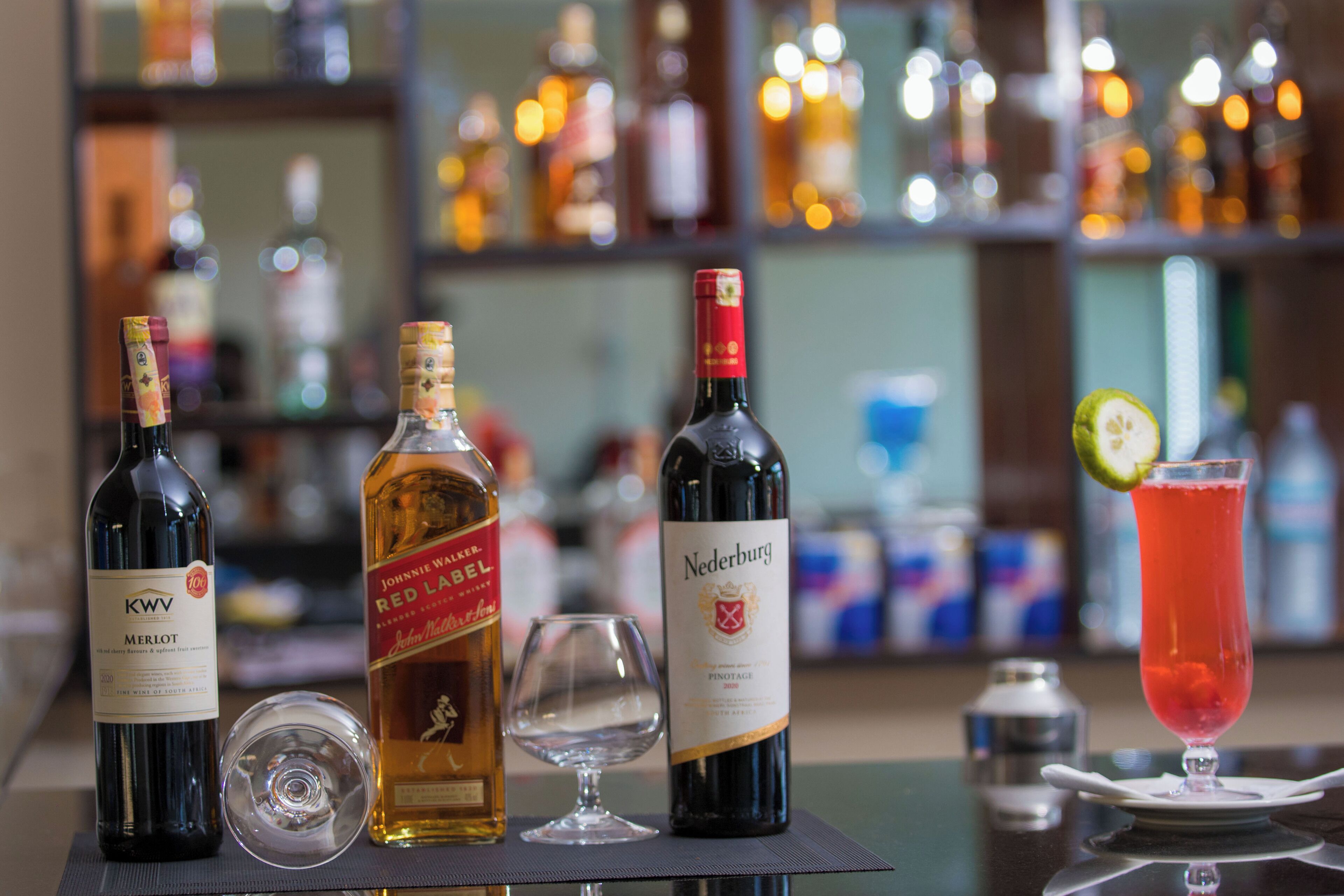 A bar setting with various bottles of wine and a cocktail glass.