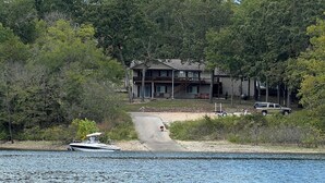 Une propriété au bord du lac comprenant une maison, un quai et un bateau.