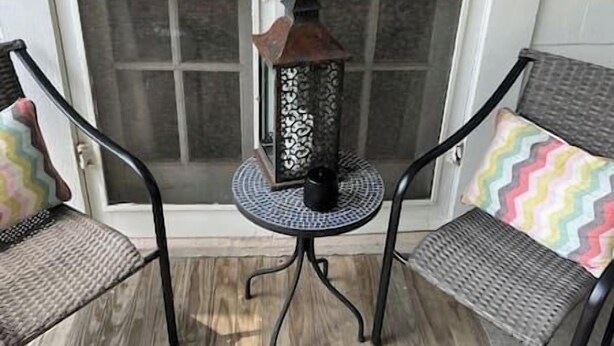 A small outdoor seating area with two chairs and a table, featuring a decorative lantern. - Historic Craftsmen Style Home (Shreveport)