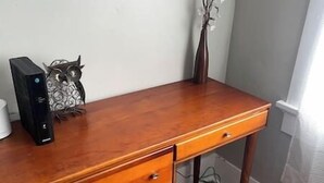 A wooden desk with a computer, a vase, and a decorative owl. - Historic Craftsmen Style Home (Shreveport)