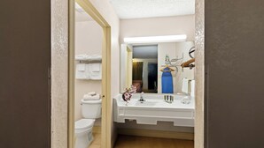 Een badkamer met toilet, wastafel en spiegel.