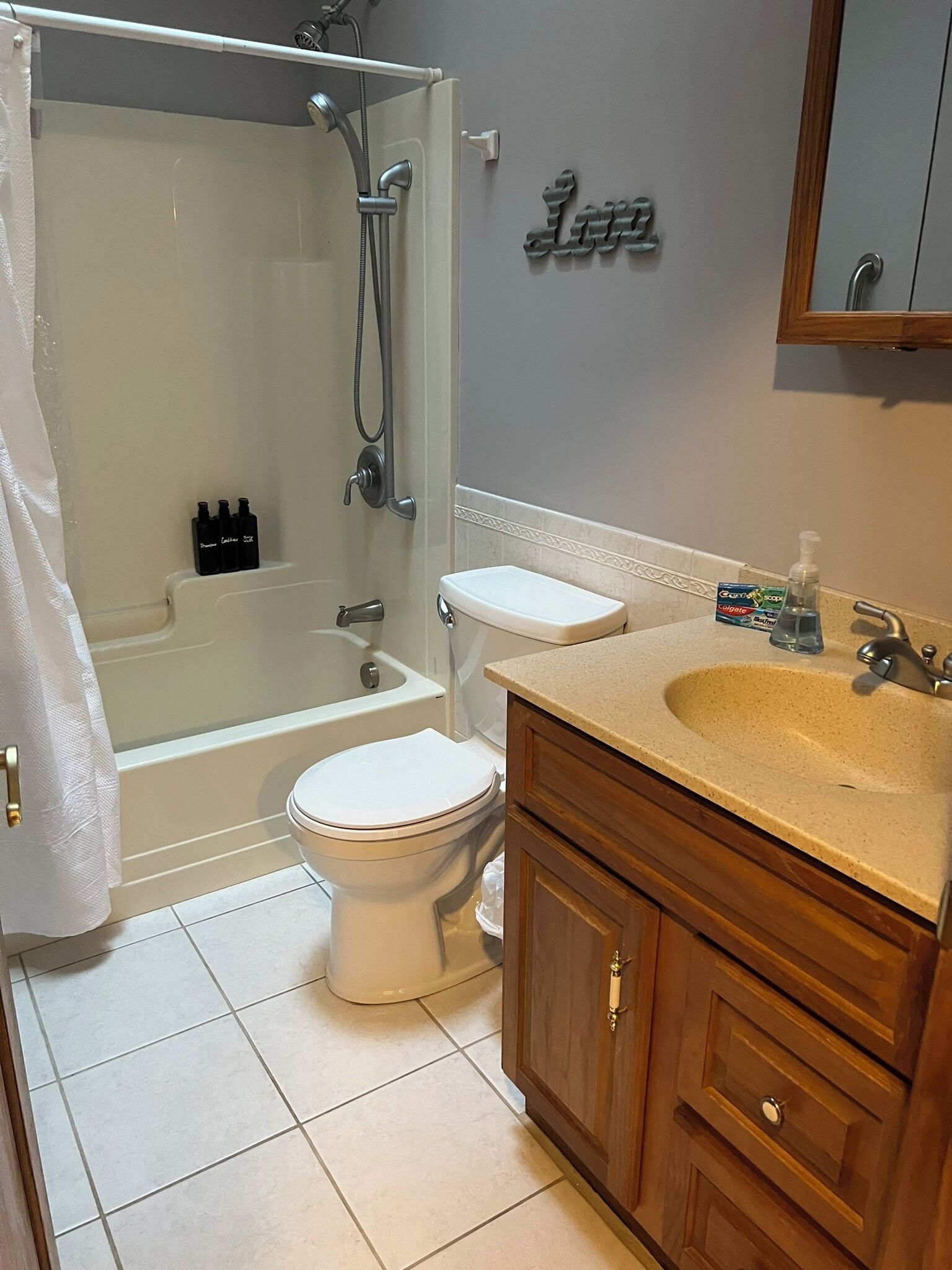 A bathroom with a bathtub, toilet, and vanity.