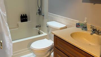 A bathroom with a bathtub, toilet, and vanity.