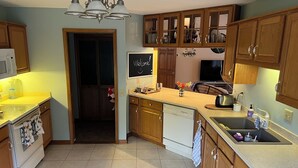 Eine Küche mit Holzausstattung, einem Geschirrspüler, einer Spüle und einer Tafel mit einem Willkommensschild.