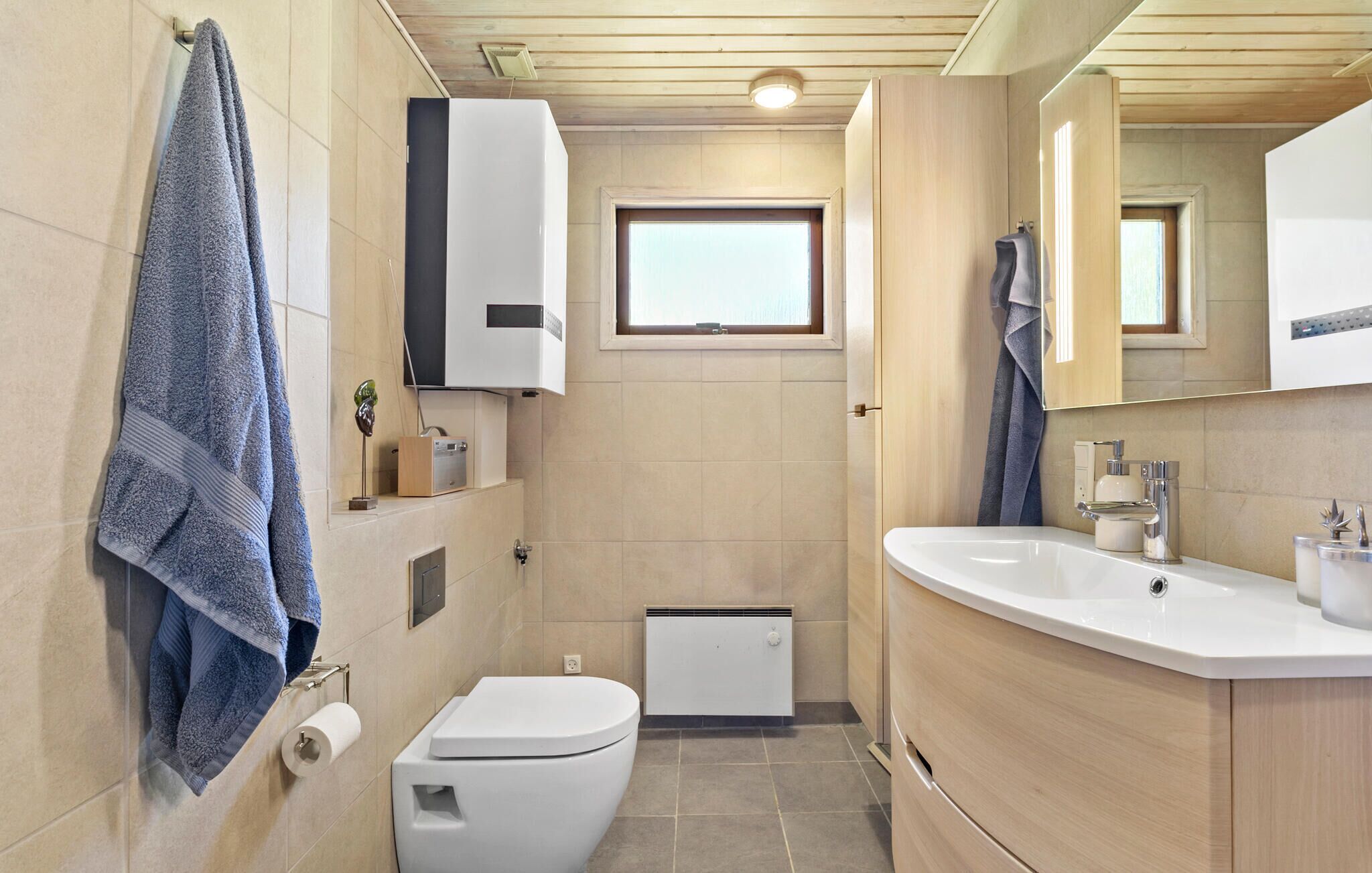 A compact bathroom with a toilet, sink, and towel rack.