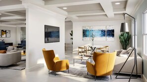 A modern living room with a sofa, two armchairs, a coffee table, and artwork on the walls. - Landing Apartments near North Fort Myers (North Fort Myers)