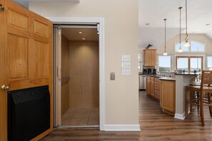 A kitchen with wooden cabinets, a black appliance, and a large island with bar stools.