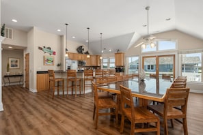 Una cocina amplia con armarios de madera, una isla grande con asientos y vistas al exterior.