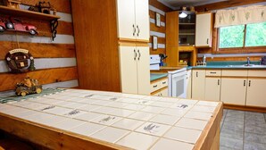 Een keuken met houten kastjes, een betegelde achterwand en een welkomstbord.