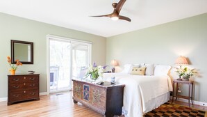Une chambre à coucher avec un lit, une commode et un ventilateur de plafond.