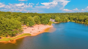 A riverside beach with a sandy shore, trees, and a clear sky. - New! Hot Tub, Fire-pit, Shuffleboard, Games Room, Kids Area in Gated Community (Albrightsville)
