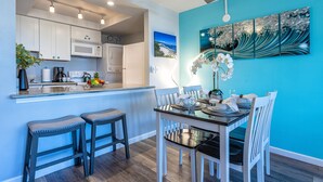 Una cocina moderna con armarios blancos, microondas y ventilador de techo.