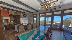 A spacious kitchen with a large island, wooden cabinets, and a view to the outside. - Seaside Hacienda, Laguna Shores Resort, 6 Bedroom (Puerto Peñasco)