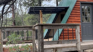 Escape to a cozy cabin surrounded by nature, with a wooden deck and a rustic charm.