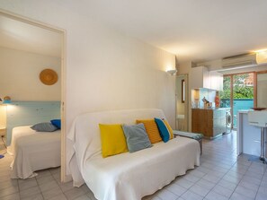 Relax in this inviting space with a sofa, woven wall hanging, and kitchenette featuring a washing machine and sink.