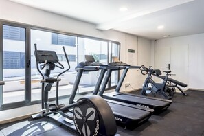 A gym with treadmills, ellipticals, and a stationary bike.