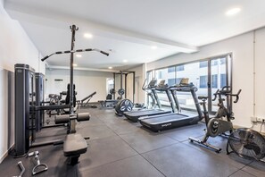 A gym with treadmills, weight machines, and a fan. - Home2Book Stylish Apartment Pool & Terrace Abades (Abades)