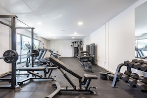 A modern gym with various exercise equipment, including treadmills, weight machines, and dumbbells. - Home2Book Stylish Apartment Pool & Terrace Abades (Abades)