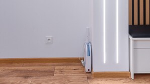 A modern room with a round mirror, a white wardrobe, and a wooden floor. - Termy Cieplice Apartment (Jelenia Góra)